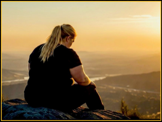 Member resting on a hilltop at sunset